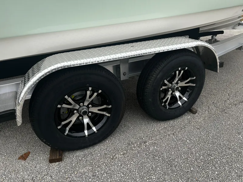 Slide: The Image of 2024 Pioneer 220 Bay Sport trailer wheels on asphalt surface. - 32