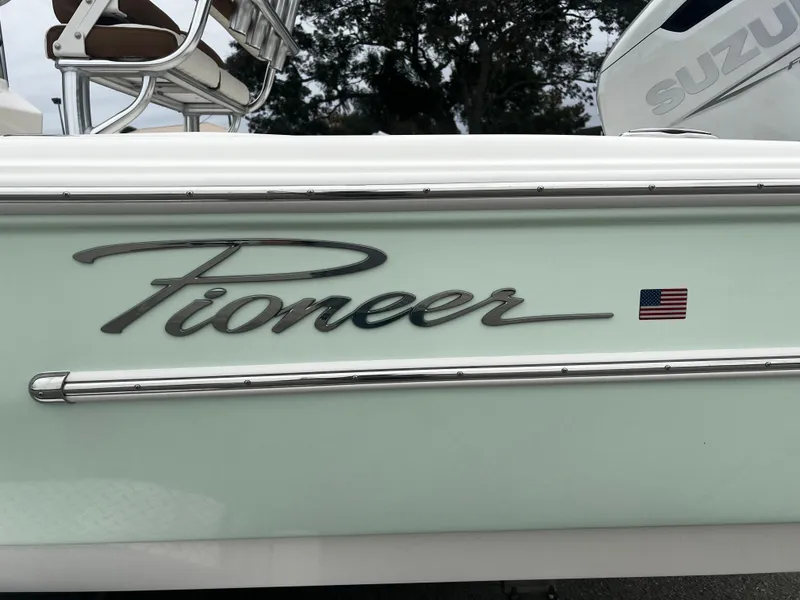 Slide: The Image of 2024 Pioneer 220 Bay Sport boat with American flag emblem. - 36