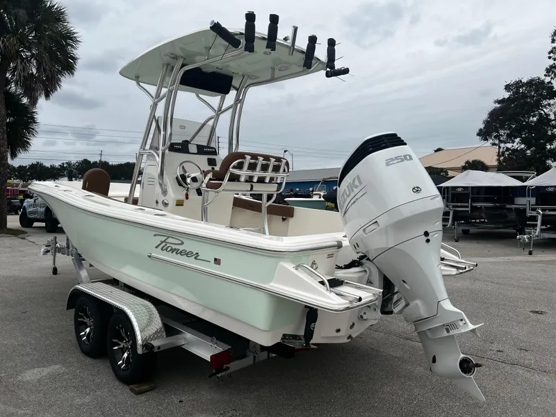 Slide: The Image of 2024 Pioneer 220 Bay Sport boat on trailer with outboard motor, parked outdoors. - 4