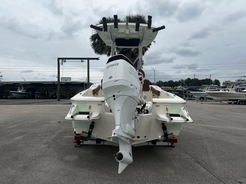 Slide: The Image of 2024 Pioneer 220 Bay Sport boat with outboard motor, parked on concrete. - 5