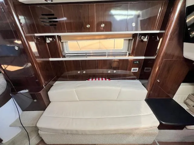 Slide: The Image of Interior of 2017 Sea Ray 330 Sundancer with wood paneling and cream seating. - 16