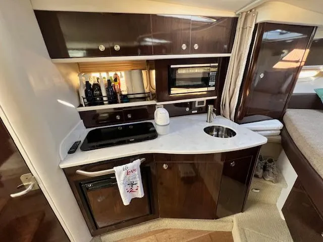 Slide: The Image of 2017 Sea Ray 330 Sundancer yacht interior kitchen with modern appliances and sleek cabinetry. - 18