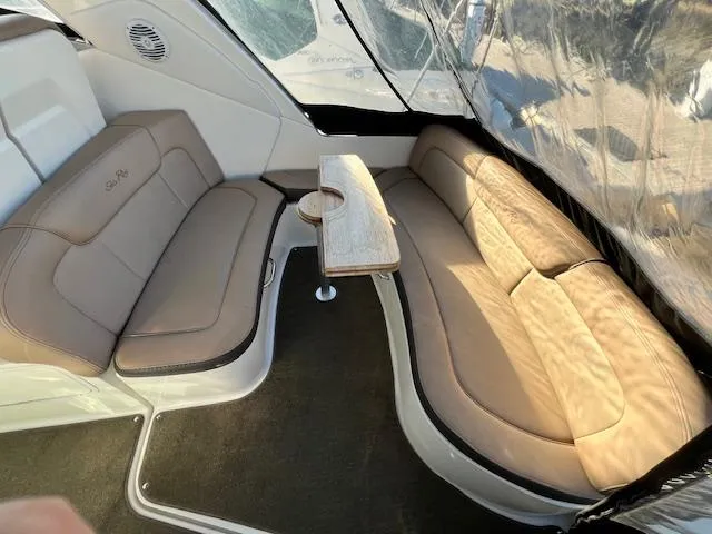 Slide: The Image of 2017 Sea Ray 330 Sundancer interior with beige seating and a small wooden table. - 5