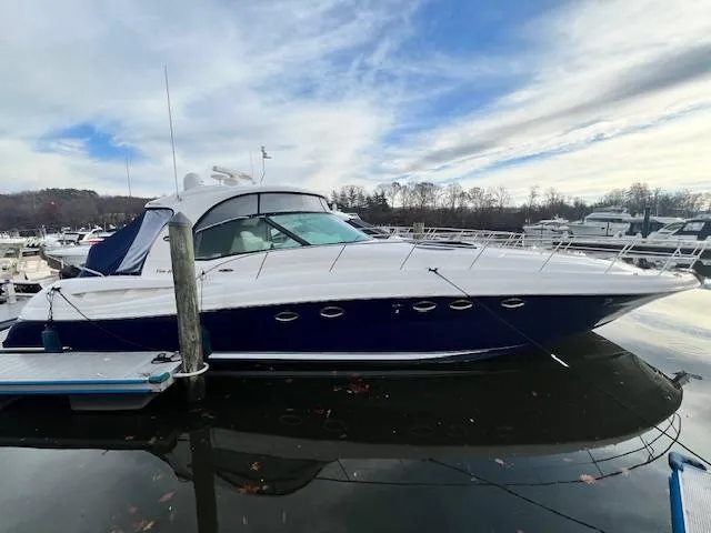 Slide: The Image of 2005 Sea Ray 500 Sundancer yacht docked at marina under cloudy sky. - 0