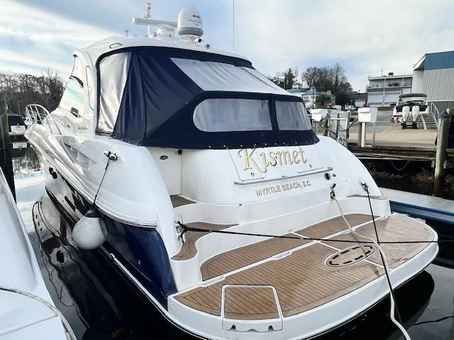 Slide: The Image of 2005 Sea Ray 500 Sundancer yacht docked, featuring a sleek design and wooden deck. - 1