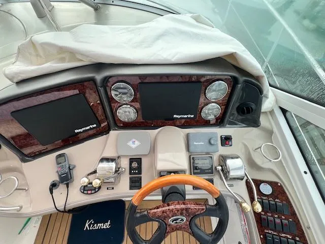 Slide: The Image of Cockpit of 2005 Sea Ray 500 Sundancer with navigation equipment and wooden steering wheel. - 12