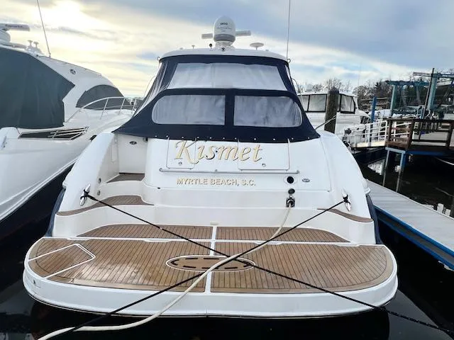 Slide: The Image of 2005 Sea Ray 500 Sundancer yacht docked, featuring teak deck and "Kismet" nameplate. - 2