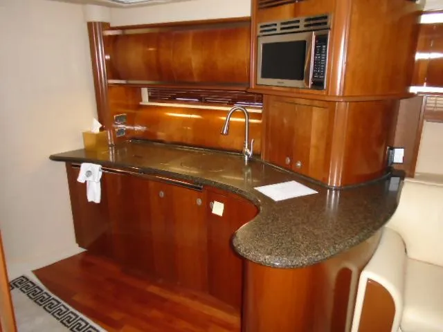Slide: The Image of Luxurious kitchen interior of 2005 Sea Ray 500 Sundancer yacht with wood cabinetry and modern appliances. - 35