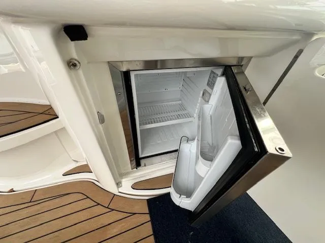 Slide: The Image of Open mini fridge on 2005 Sea Ray 500 Sundancer yacht with wooden deck flooring. - 42
