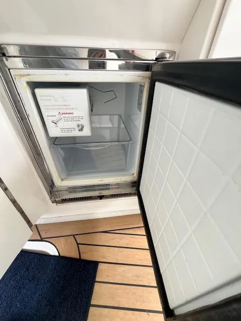 Slide: The Image of Open refrigerator on 2005 Sea Ray 500 Sundancer yacht, showing interior and wooden flooring. - 43