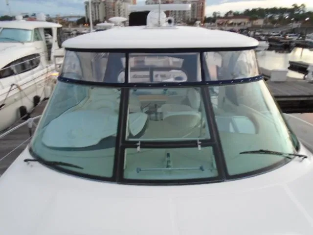 Slide: The Image of 2005 Sea Ray 500 Sundancer yacht docked at marina, showcasing sleek windshield design. - 9