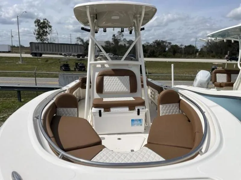 Slide: The Image of 2024 Pioneer Islander 222 boat with cushioned seating and T-top, docked outdoors. - 11