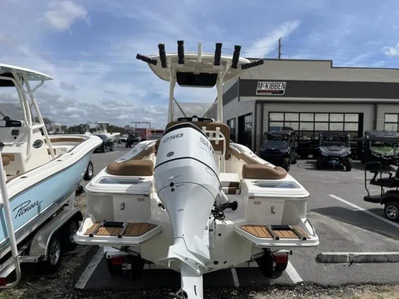 Slide: The Image of 2024 Pioneer Islander 222 boat with powerful outboard motor in a dealership lot. - 15