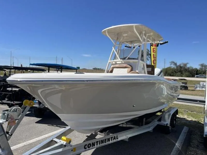 Slide: The Image of 2024 Pioneer Islander 222 boat on trailer under clear blue sky. - 25