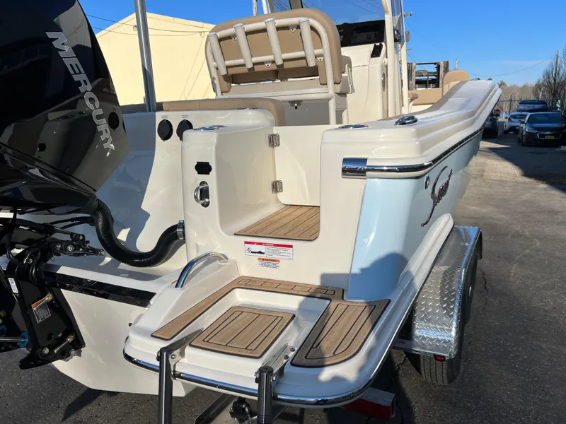 Slide: The Image of 2024 Scout 215 XSF boat with Mercury engine, featuring teak swim platform and seating. - 11