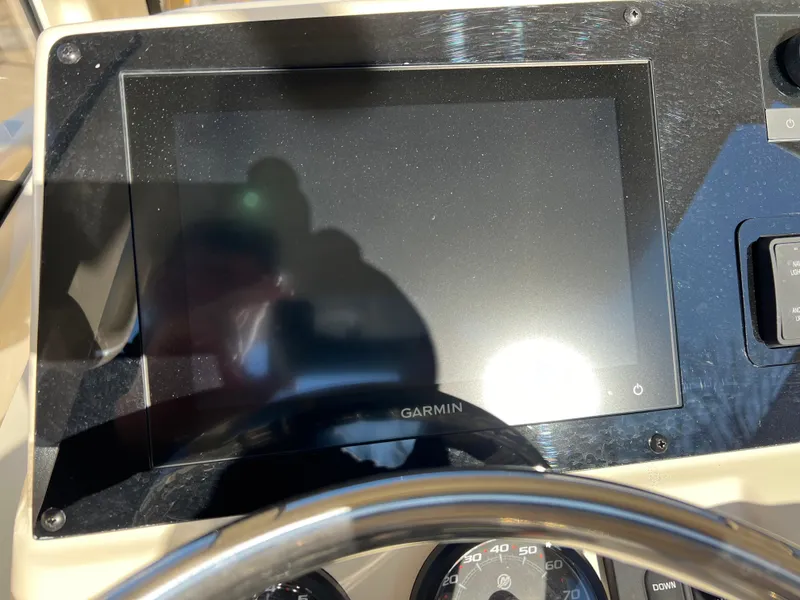Slide: The Image of Garmin display on 2024 Scout 215 XSF boat dashboard, reflecting sunlight. - 16