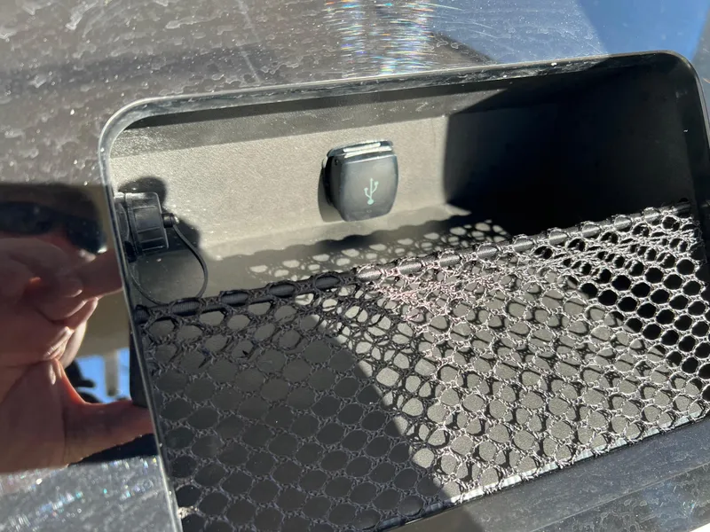 Slide: The Image of 2024 Scout 215 XSF storage compartment with USB port and netting. - 21