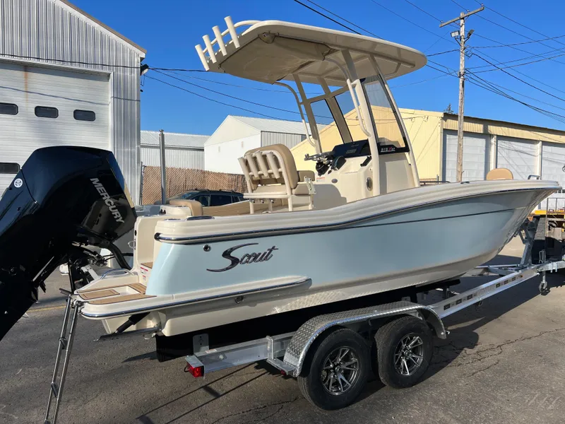 Slide: The Image of 2024 Scout 215 XSF boat on trailer, parked outdoors. - 4
