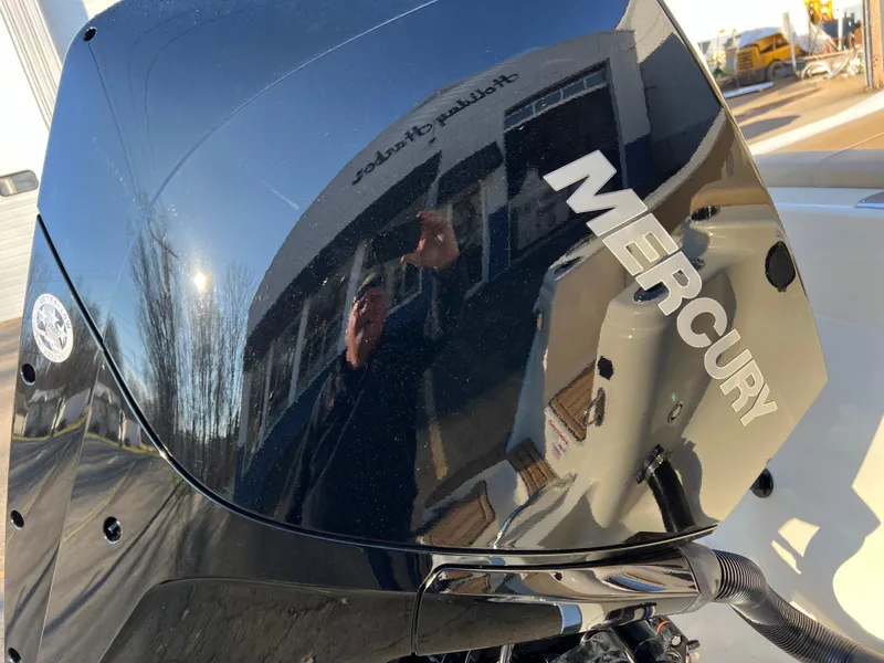Slide: The Image of Mercury engine on 2024 Scout 215 XSF boat, reflecting surroundings. - 6