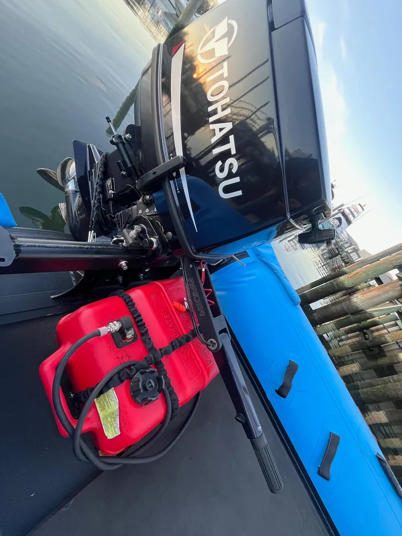 Slide: The Image of Outboard motor on a boat with red fuel tank, dockside view. - 2