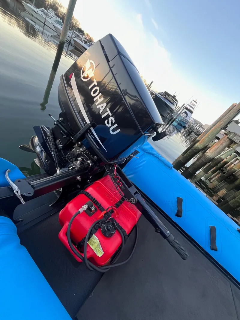 Slide: The Image of Blue Infanta P1 Pencil boat with Tohatsu outboard motor, docked by the water. - 4