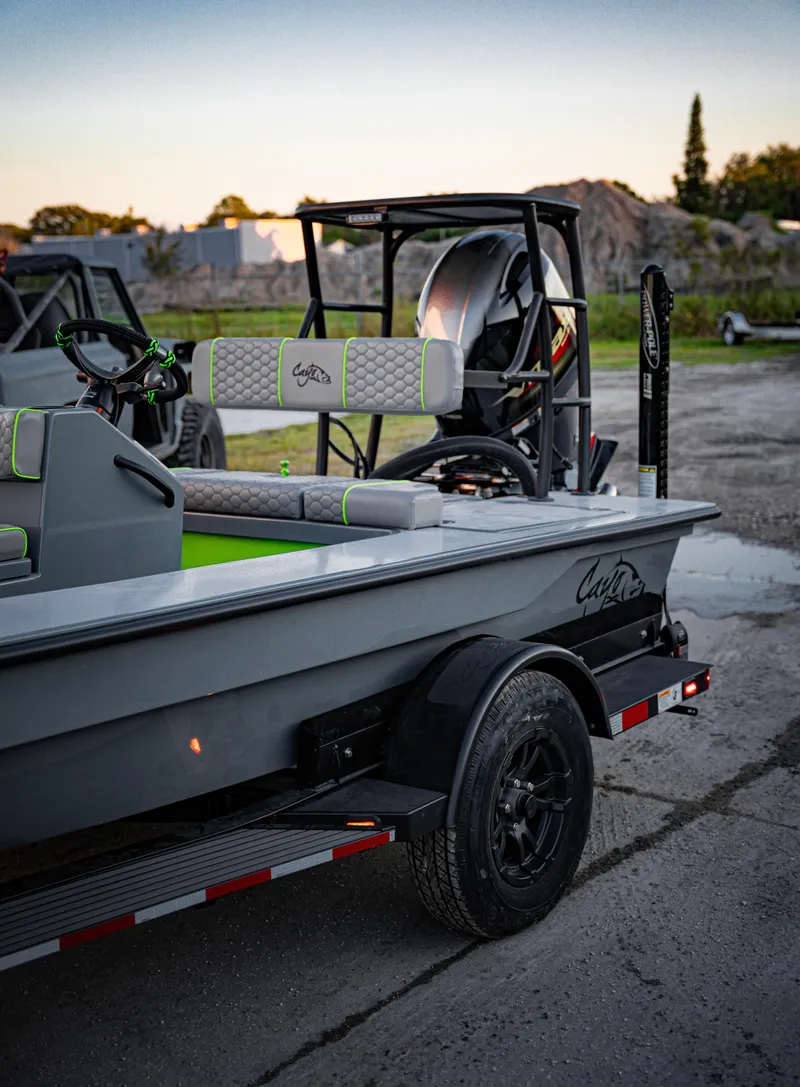 Slide: The Image of 2024 Cayo Boatworks 180 on trailer, rear view with motor and seating. - 12