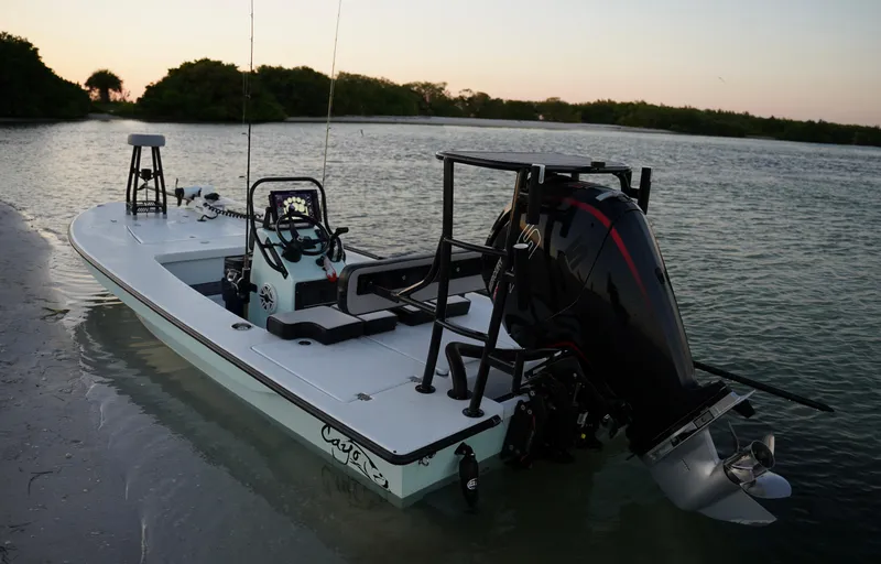 Slide: The Image of 2024 Cayo Boatworks 180 model docked in shallow water at sunset. - 13