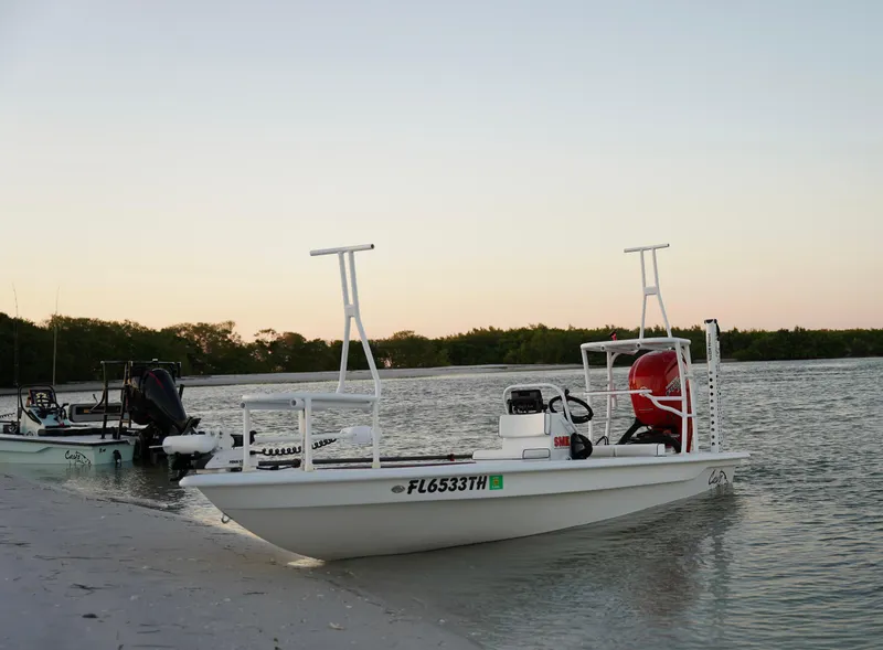 Slide: The Image of 2024 Cayo Boatworks 180 on a sandy shore at sunset. - 15