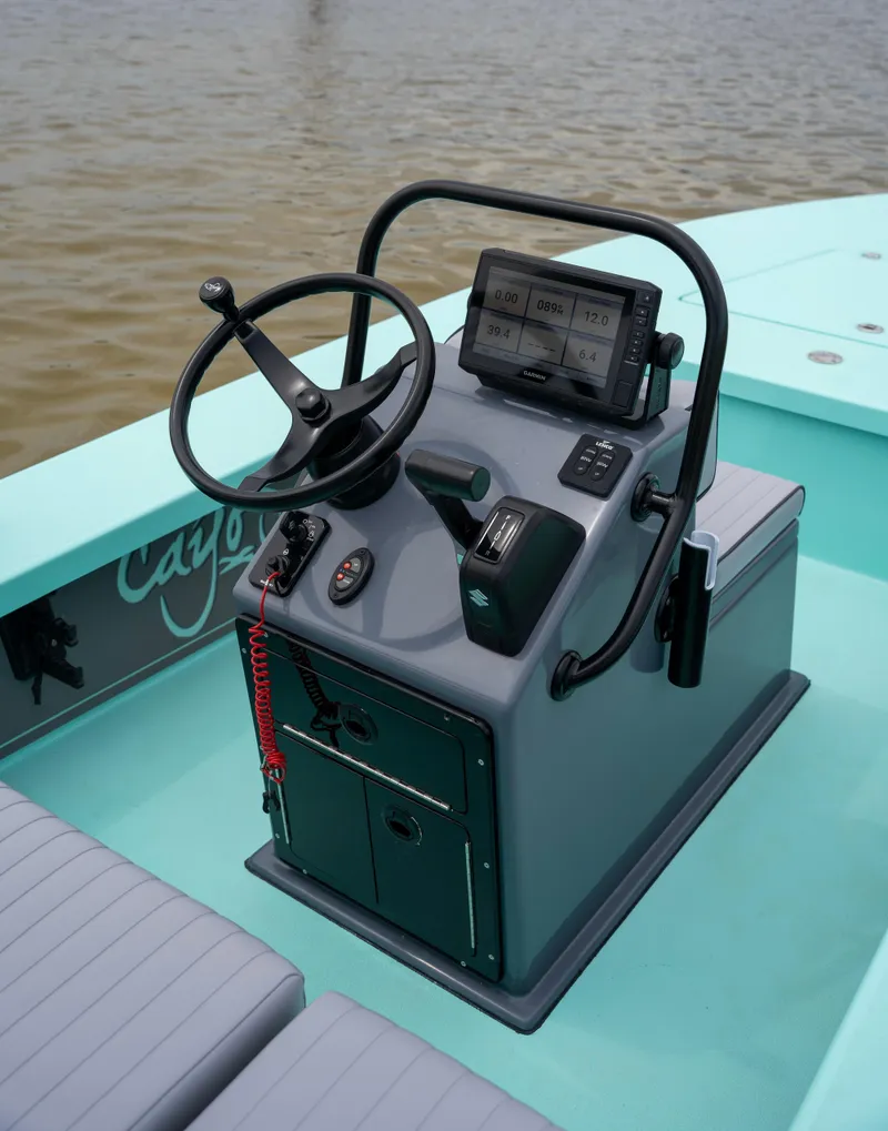 Slide: The Image of 2024 Cayo Boatworks 180 center console with steering wheel and navigation system. - 2