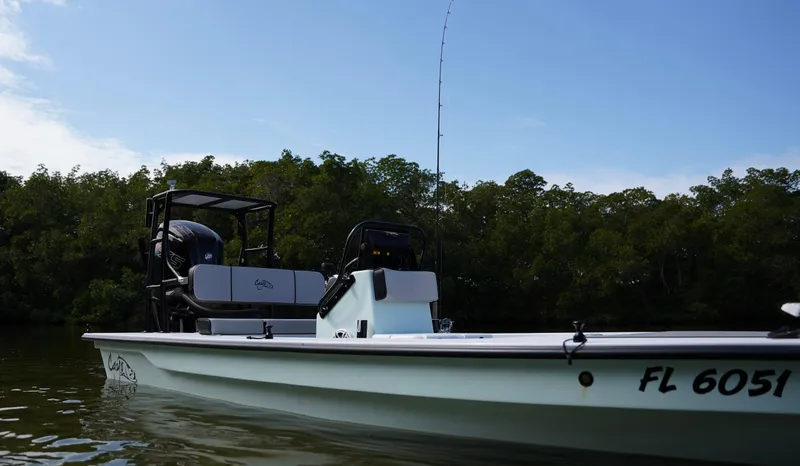 Slide: The Image of 2024 Cayo Boatworks 180 in water, side view with trees in background. - 20