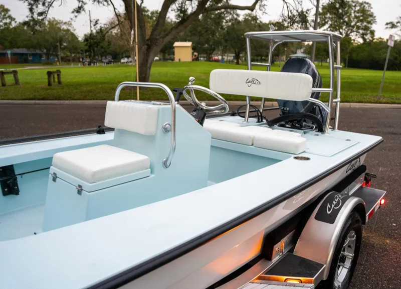 Slide: The Image of 2024 Cayo Boatworks 180 model on trailer, featuring white seating and steering console. - 22
