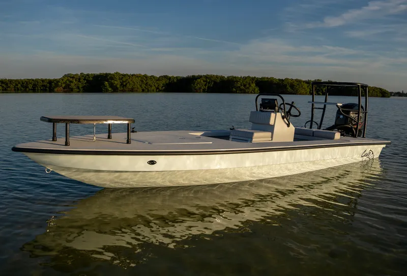 Slide: The Image of 2024 Cayo Boatworks 180 model on calm water with scenic background. - 25