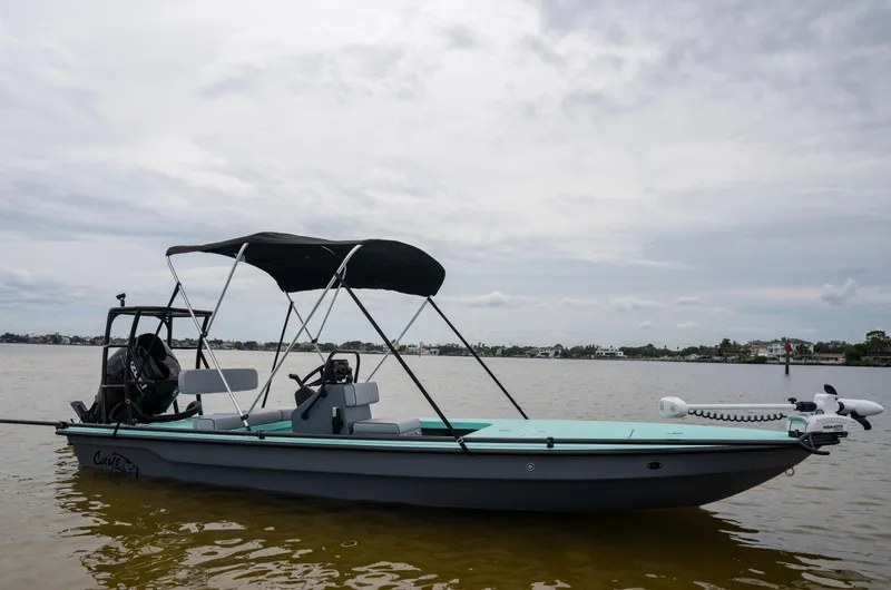 Slide: The Image of 2024 Cayo Boatworks 180 on calm water with a black canopy. - 26