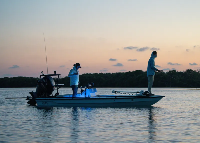 Slide: The Image of Two people fishing on a 2024 Cayo Boatworks 180 at sunset. - 7