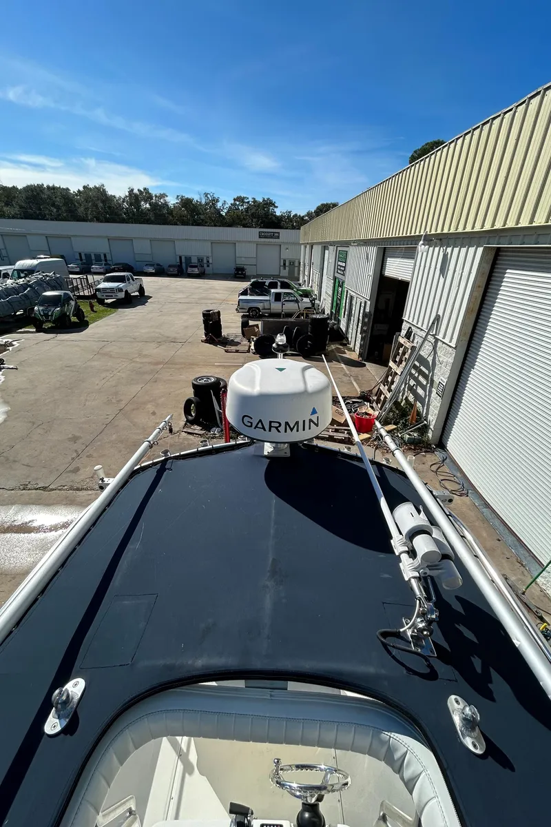 Slide: The Image of 2015 Boston Whaler 210 Montauk with Garmin equipment, docked near industrial buildings. - 15