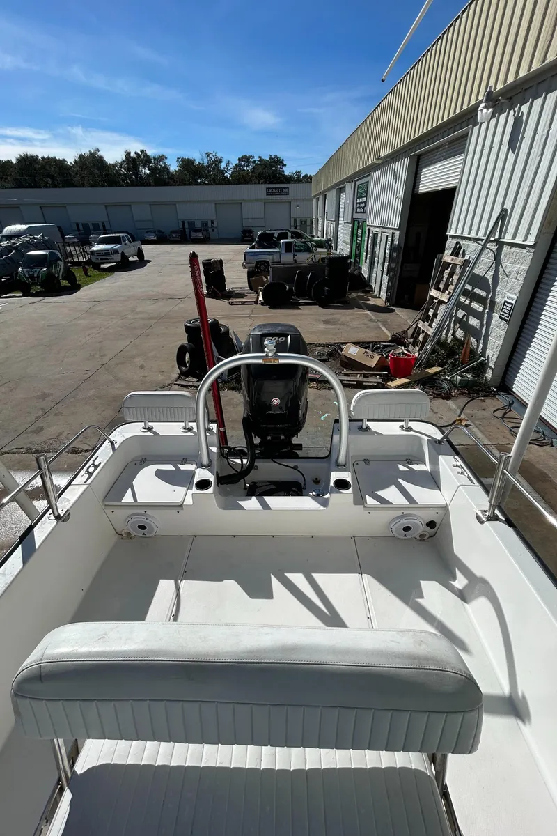 Slide: The Image of 2015 Boston Whaler 210 Montauk boat at a marina, sunny day, industrial background. - 16