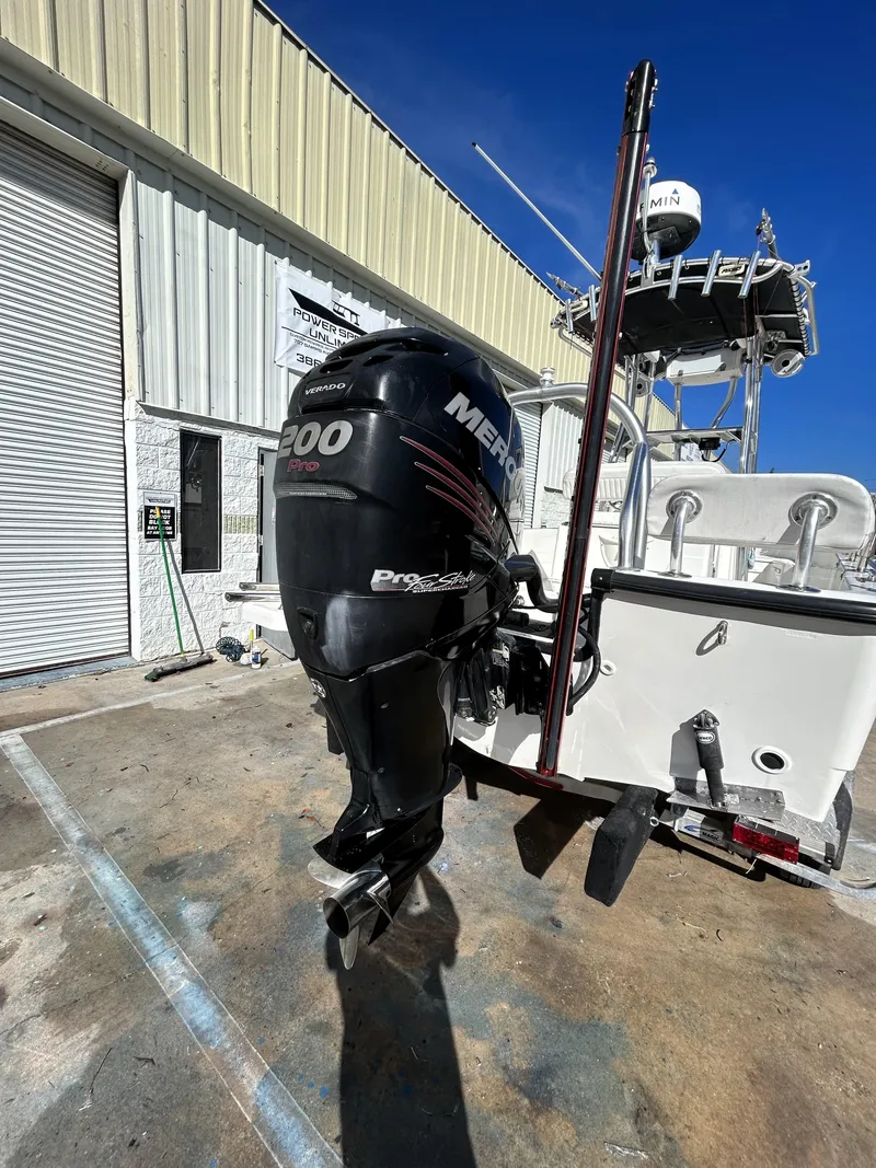Slide: The Image of 2015 Boston Whaler 210 Montauk with Mercury outboard motor, parked outdoors. - 8