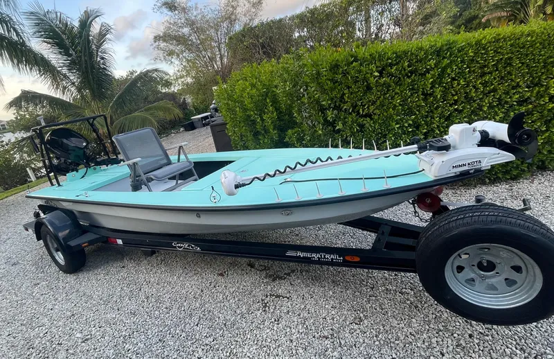 Slide: The Image of 2024 Cayo Boatworks 173 on trailer, turquoise hull, parked on gravel driveway. - 20