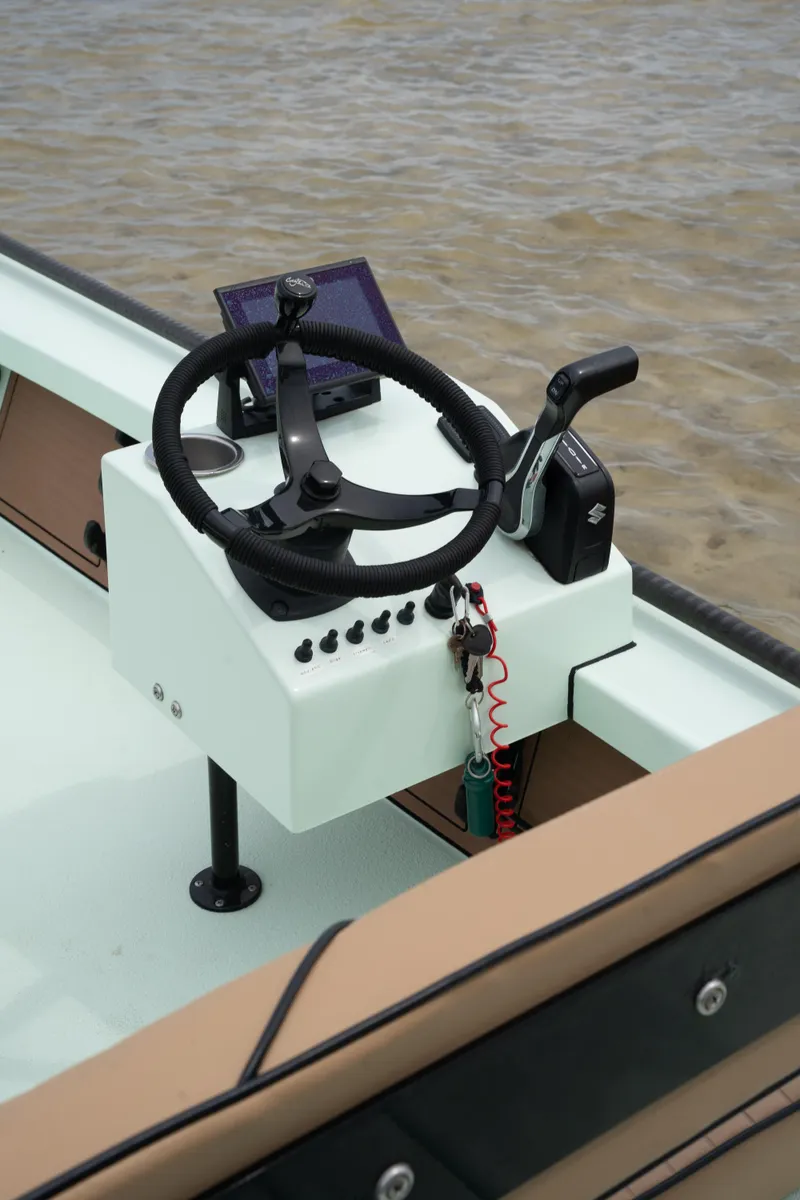 Slide: The Image of 2024 Cayo Boatworks 173 steering console with controls and navigation display. - 22