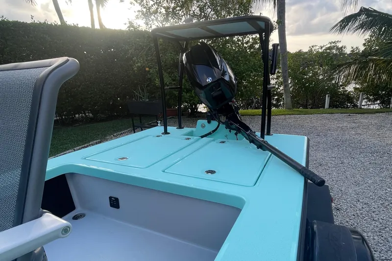 Slide: The Image of 2024 Cayo Boatworks 173 with outboard motor, turquoise deck, and seating area. - 24
