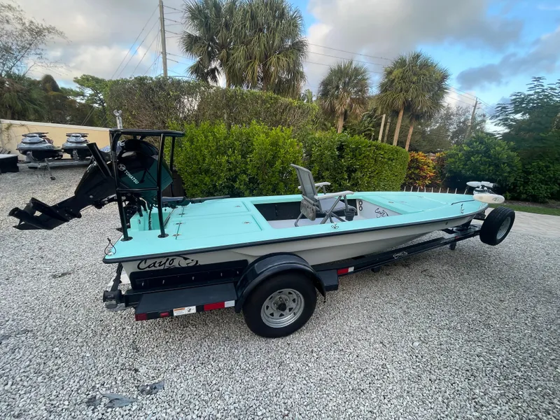 Slide: The Image of 2024 Cayo Boatworks 173 on trailer, light blue deck, parked on gravel. - 25