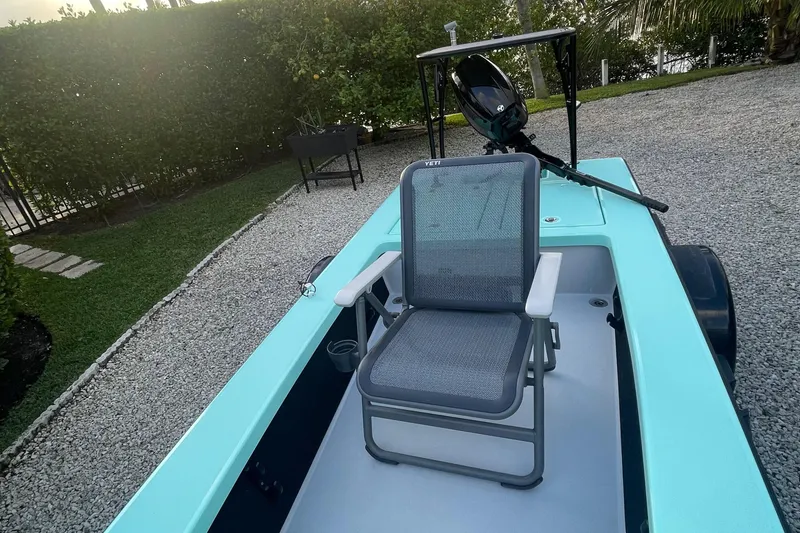 Slide: The Image of 2024 Cayo Boatworks 173 with a single seat on deck, parked on gravel. - 26