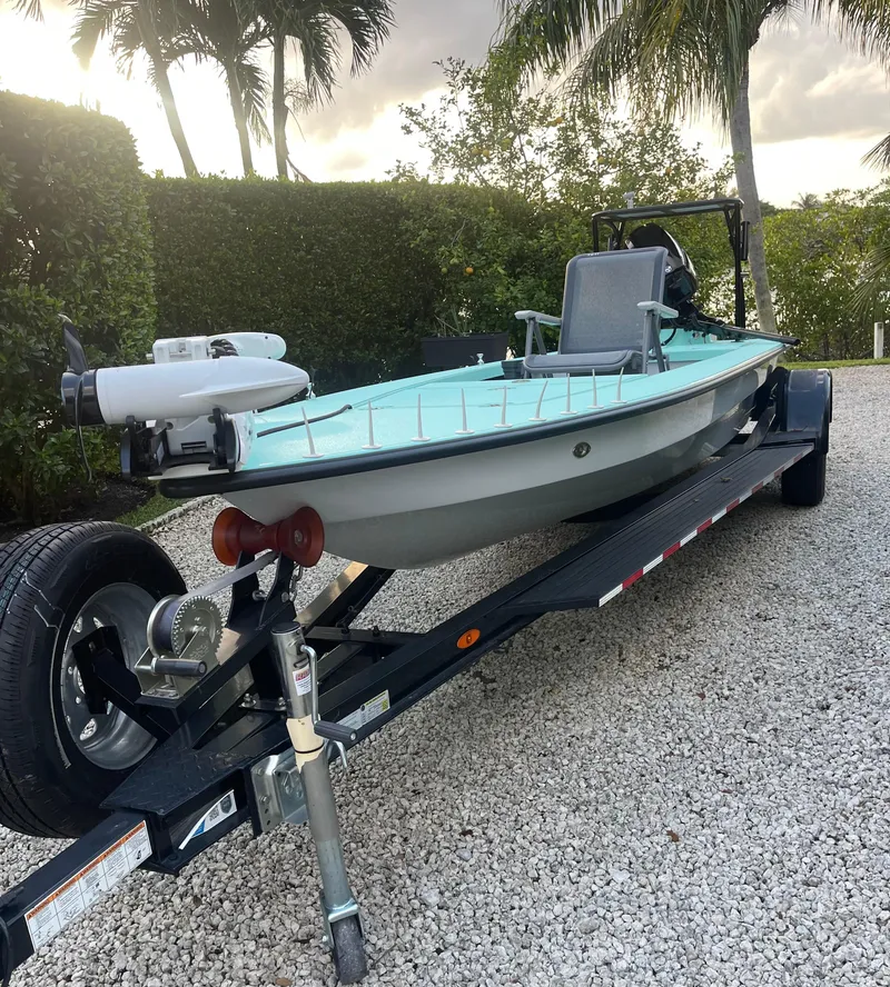Slide: The Image of 2024 Cayo Boatworks 173 on trailer, parked on gravel with palm trees in background. - 38
