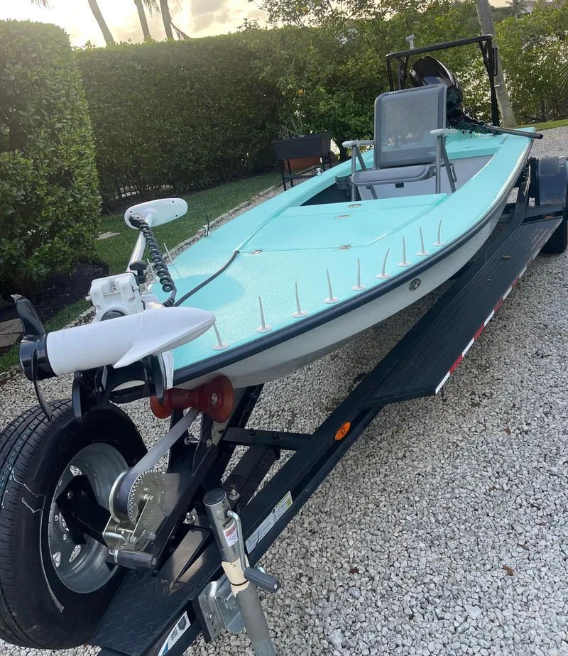 Slide: The Image of 2024 Cayo Boatworks 173 on a trailer, light blue hull, parked on gravel. - 39