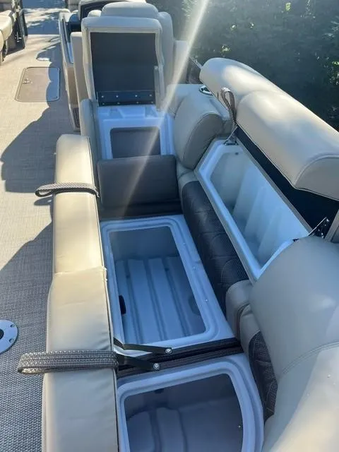 Slide: The Image of 2024 Regency 250 LE3 boat with open storage compartments and beige seating. - 11