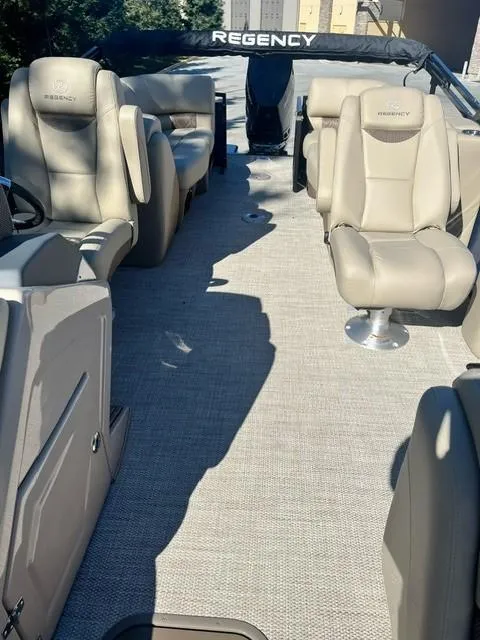 Slide: The Image of 2024 Regency 250 LE3 pontoon boat interior with beige seating and carpet. - 16