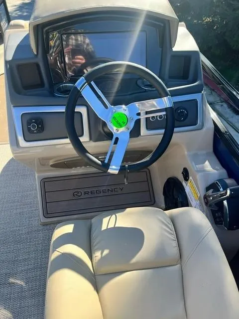 Slide: The Image of 2024 Regency 250 LE3 boat dashboard with steering wheel and control panel. - 17