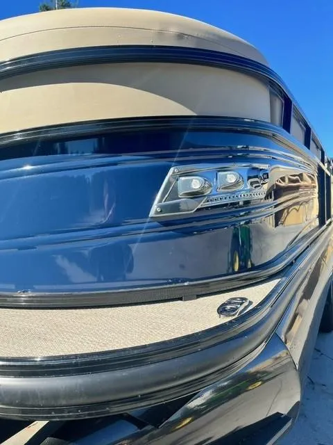 Slide: The Image of 2024 Regency 250 LE3 pontoon boat with sleek chrome detailing. - 2
