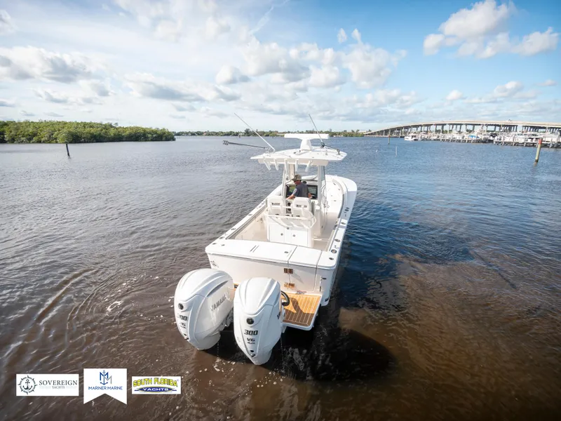 Slide: The Image of 2024 Regulator 28 boat with twin engines on a sunny day, near a bridge. - 11
