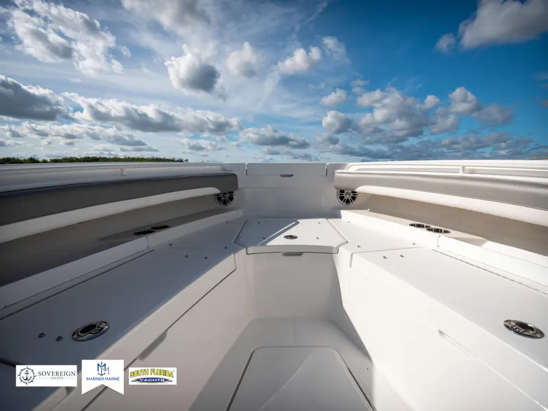 Slide: The Image of 2024 Regulator 28 boat interior with spacious seating under a cloudy sky. - 17